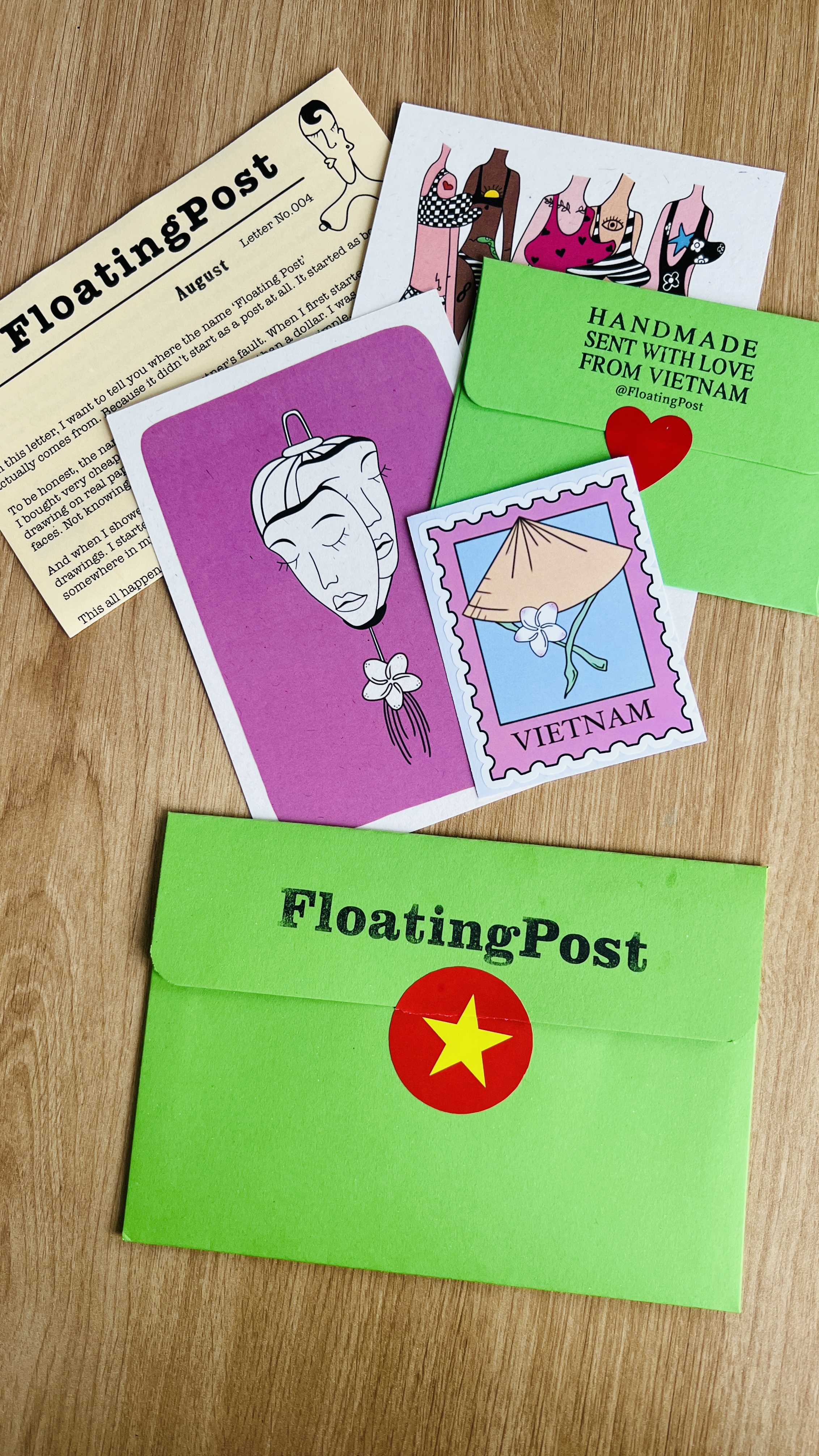 Issue 004's August letter and swimsuit-ladies art print next to a purple mask card and a green Floating Post envelope